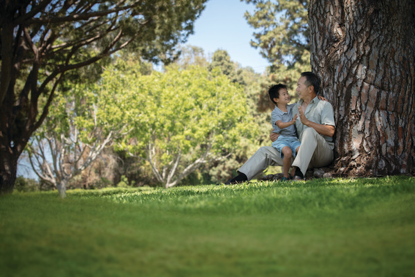 grandfather and grandson under tree