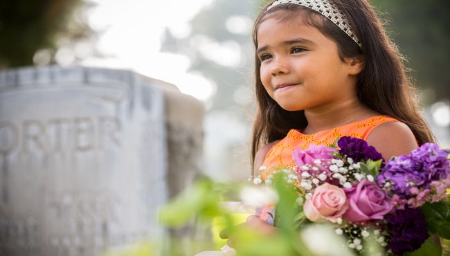Young girl delivering flowers in memory of a loved one.